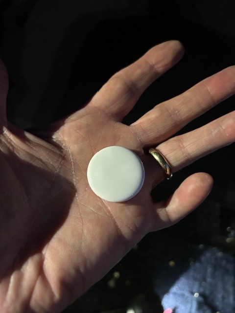 The Front of an Apple Air Tag we detected 9/16/2025 from a customer's car